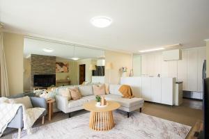 シドニーにあるFamily 3BR Retreat with Pool, Gym & Parkingのソファとテーブルのあるリビングルーム