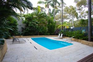シドニーにあるFamily 3BR Retreat with Pool, Gym & Parkingのラウンジチェア2脚とスイミングプール1つが備わります。