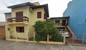 a house with a fence in front of it at Casa de veraneio 2 dormitórios in Torres