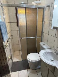 ein Badezimmer mit Dusche, Toilette und Waschbecken in der Unterkunft Casa de veraneio 2 dormitórios in Torres