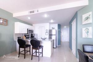 una cucina con 2 sedie e un bancone con frigorifero di Sonoran Spa N502 a Campo del Medio