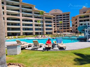 una persona seduta sulle sedie di fronte alla piscina di Sonoran Spa N502 a Campo del Medio