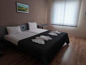 a bedroom with a bed with two towels on it at ATM Hotel in Sofia
