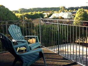 two blue chairs sitting on a balcony at Spacious City Apartment With Amazing Views in Christchurch