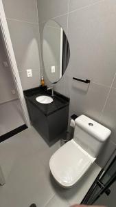 a bathroom with a white toilet and a mirror at Studios Gago 167 in Suzano