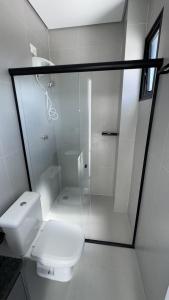 a white bathroom with a shower and a toilet at Studios Gago 167 in Suzano
