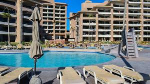 een zwembad met stoelen en een parasol en enkele gebouwen bij Sonoran Spa N603 in Campo del Medio +13 foto's