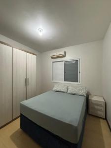 a bedroom with a large bed and a window at Casa para oktoberfest em Blumenau in Blumenau
