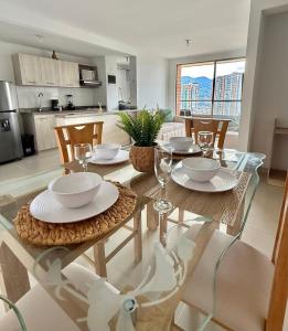 ein Esszimmer mit einem Tisch mit Tellern und Weingläsern in der Unterkunft Ronnie in Sabaneta