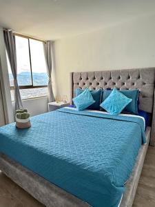 Schlafzimmer mit einem großen blauen Bett und einem Fenster in der Unterkunft Ronnie in Sabaneta