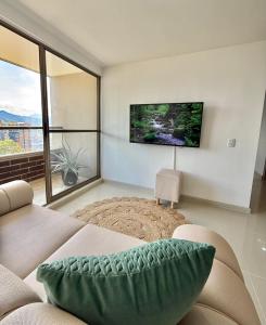 ein Wohnzimmer mit Couch und großem Fenster in der Unterkunft Ronnie in Sabaneta