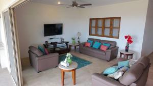 a living room with two couches and a mirror at Condo Ventanas El Arco Views & Pool in Cabo San Lucas