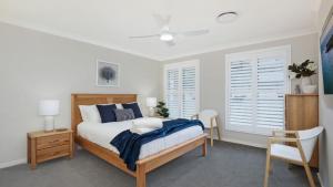 a bedroom with a bed and two windows at Coastal Drift in Callala Bay