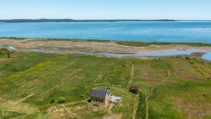 an aerial view of a house in a field next to the water at Sunrise by the Sea in Lubec
