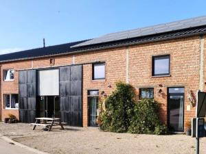 - un bâtiment en briques avec une table de pique-nique devant dans l'établissement Single-storey holiday home in Heers, à Heers