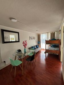 ein Wohnzimmer mit einem Tisch, Stühlen und einem Bett in der Unterkunft santiago apart in Santiago