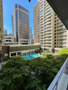 Blick auf einen Pool in einer Stadt mit hohen Gebäuden in der Unterkunft santiago apart in Santiago