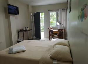 a bedroom with a bed and a table and a chair at Casita Angela in Panglao