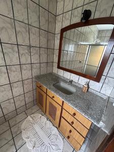 un baño con lavabo y espejo en Morada dos Pomares, en Pomerode