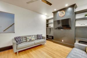 a living room with a couch and a flat screen tv at Walk to Tower Grove Park St Louis Getaway in Tower Grove
