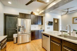 a kitchen with wooden cabinets and a stainless steel refrigerator at Walk to Tower Grove Park St Louis Getaway in Tower Grove