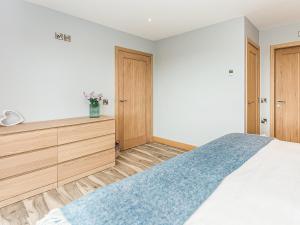 a bedroom with a bed and wooden cabinets at High Tide - Uk44283 in Gatehouse of Fleet +7 photos