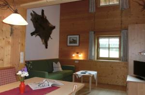 ein Wohnzimmer mit einem grünen Sofa und einem Tisch in der Unterkunft Haus Gstüat in Lech am Arlberg