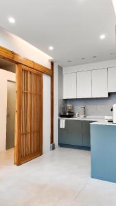 a kitchen with white cabinets and a wooden door at Eosahwa in Jeonju