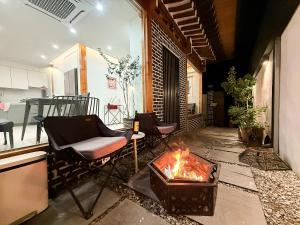 a living room with two chairs and a fire pit at Eosahwa Hanok Stay Featured in Petit Futé 2026 in Jeonju
