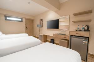 a hotel room with two beds and a flat screen tv at Kemet Hotel Tahrir Square in Cairo