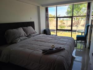 a bedroom with a bed with a cup of coffee on it at Hospedaje Residencial Aeropuerto in Zamacola