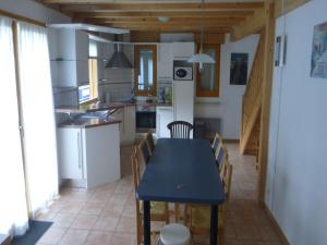 a kitchen and dining room with a blue table and chairs at Chalet in Saint-Jean near Ski Lift in Saint-Jean-d'Aulps