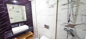 a bathroom with a sink and a shower with a mirror at Cozy Apartment Near Airport in Nouaceur