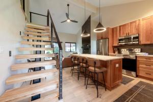 een keuken met een wenteltrap en een bar met krukken bij Hidden Creek 37D condo in Park West Ski Area Heliport