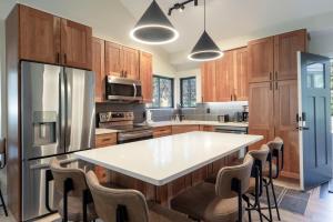 een keuken met houten kasten en een grote witte tafel bij Hidden Creek 37D condo in Park West Ski Area Heliport