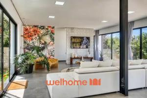 a living room with a white couch and a wall of windows at Suite em Tibau do Sul proximo as Dunas do Chapadao in Pipa