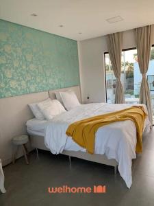 a bedroom with a large bed with a yellow blanket at Suite em Tibau do Sul proximo as Dunas do Chapadao in Pipa
