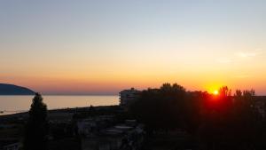 a sunset over the ocean and a city at Hotel Kapsul Vlore in Vlorë +25 photos