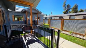 a porch of a house with a fence and a chair at Parkside Cabins in West Yellowstone