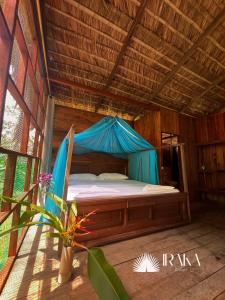a bed in a room with a blue tent at Ecohotel Iraka Cabañas Privadas en Selva y Playa in Bahía Solano