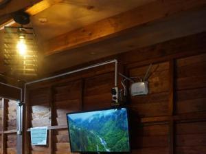 a flat screen tv on a wall in a room at Danial Cabin Dieng in Diyeng