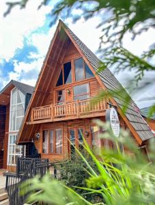Cette grande maison en bois possède un balcon. dans l'établissement Danial Cabin Dieng, à Diyeng