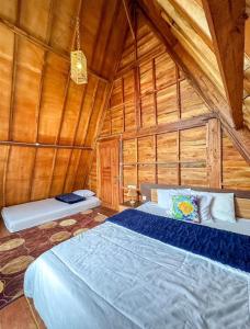 une chambre avec un lit dans une cabane en bois dans l'établissement Danial Cabin Dieng, à Diyeng