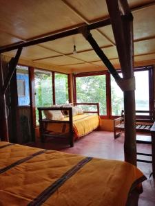 a bedroom with a bed in a room with windows at Ecolodge Rancho del Lago in Santomé +47 photos