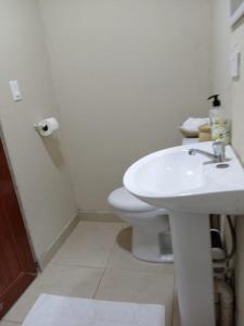 Un baño con un inodoro blanco y un lavabo. en Casa Real, en Panamá