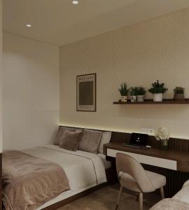 a bedroom with a bed and a desk with a laptop at The Kind Villas Phu Quoc in Phu Quoc