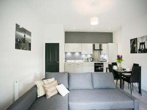 a living room with a couch and a kitchen at Queens Quarter Apartments in Belfast