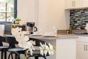 カボ・サン・ルーカスにあるVista Pedregal-Modern Vacation Apartment Walk to Marina & Beachesのキッチン(白いキャビネット、カウンター、椅子付)