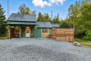 eine kleine grüne Hütte mit einer Kiesauffahrt in der Unterkunft Cozy Cottage Retreat Private 2 Acres, Near Lake in Harcourt