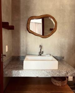 Un baño con un lavabo blanco y un espejo. en Bali BG Casa Bamboo, en Barra Grande